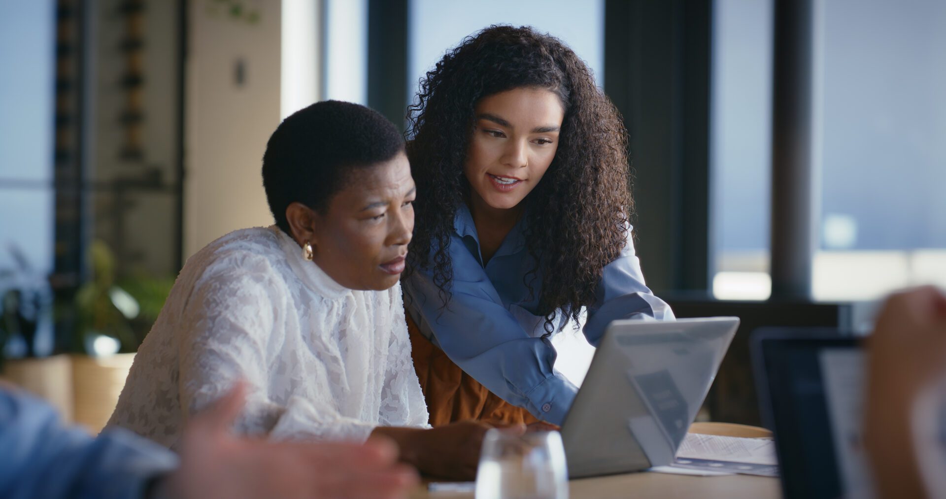Colleagues discussing work project indoors
