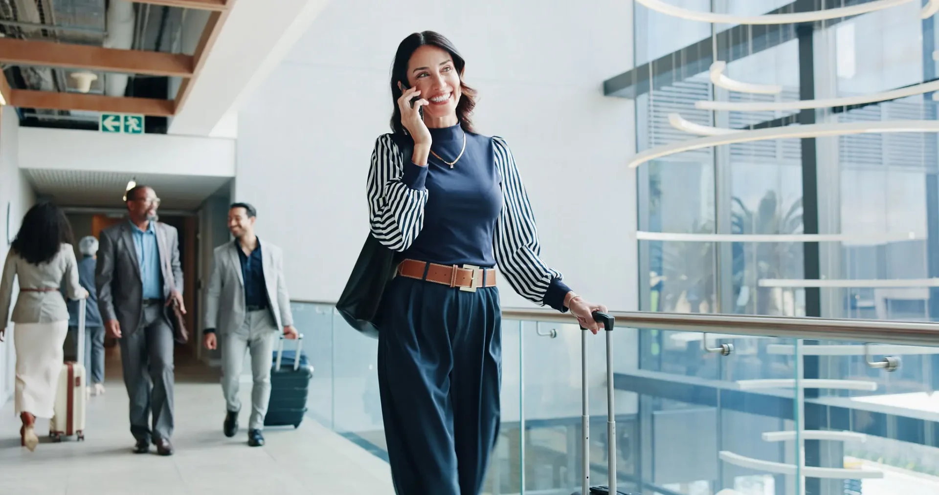 Woman talking on phone while walking in airport terminal.