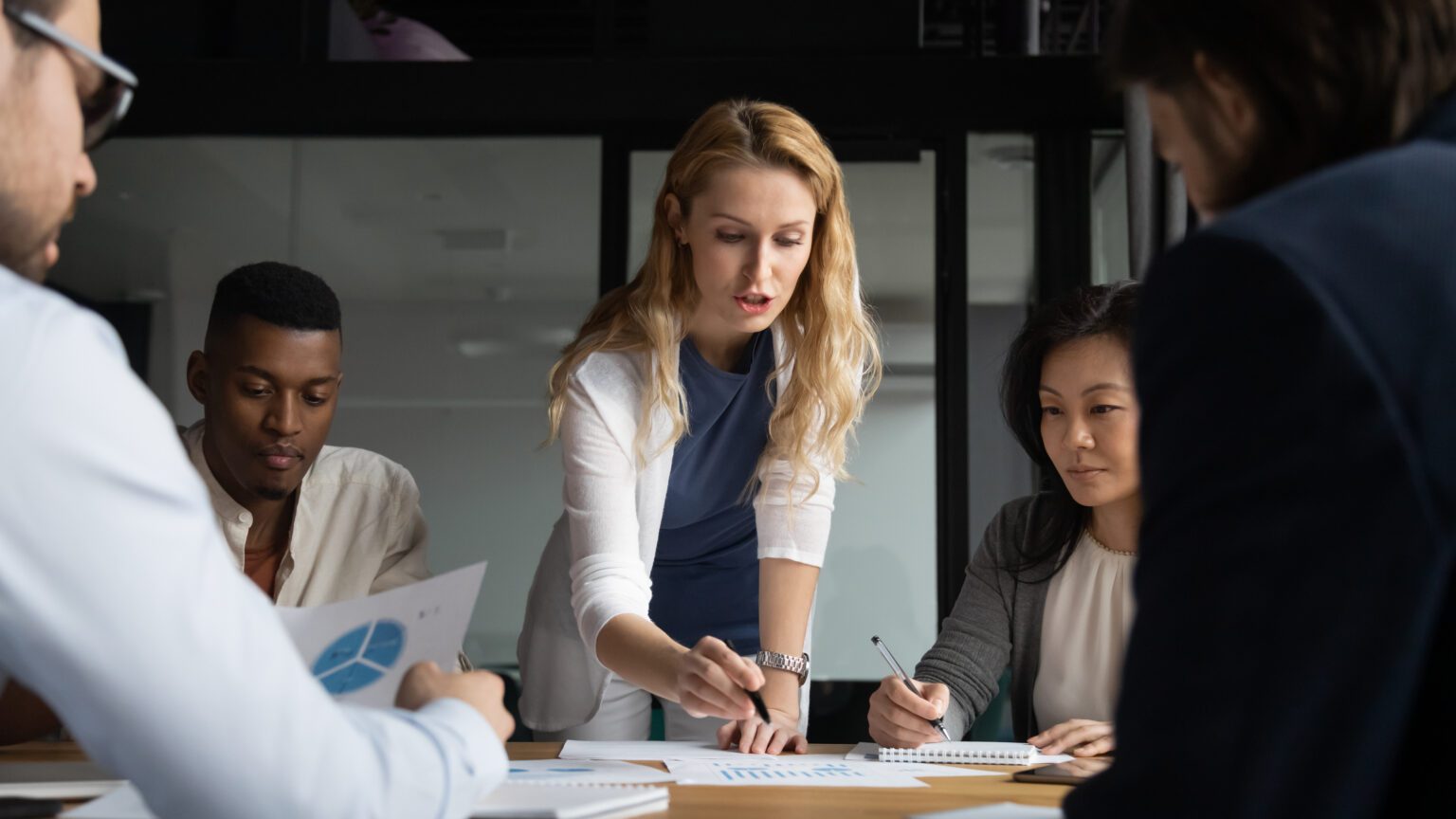 A woman leading a business meeting with attentive colleagues.